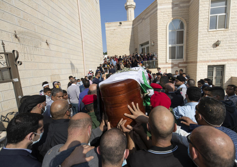 A Palestinian honor guard carries the body Saeb Erekat into a mosque during his funeral in the West Bank city of Jericho, Wednesday, Nov. 11, 2020. Erekat, a veteran peace negotiator and prominent international spokesman for the Palestinians for more than three decades, died on Tuesday, weeks after being infected by the coronavirus. He was 65. (AP Photo/Nasser Nasser)