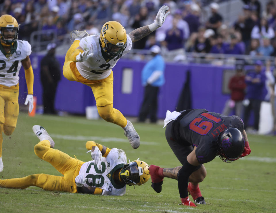 TCU tight end Jared Wiley (19) pulls down a long pass over Baylor safety Devyn Bobby (28) and linebacker Matt Jones (2) in the second half of an NCAA college football game, Saturday, Nov. 18, 2023, in Fort Worth, Texas. (Rod Aydelotte/Waco Tribune-Herald via AP)