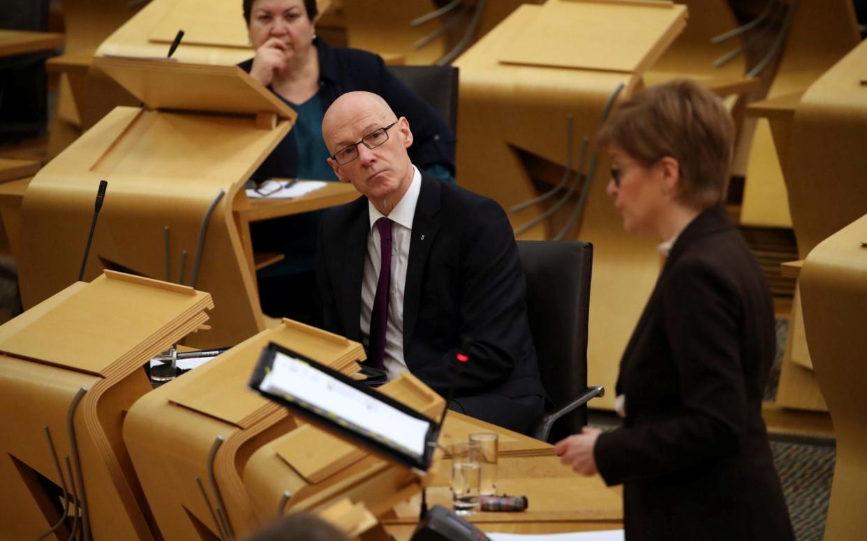 John Swinney, the Deputy First Minister, looks on as Nicola Sturgeon addresses MSPs - Pool/REUTERS