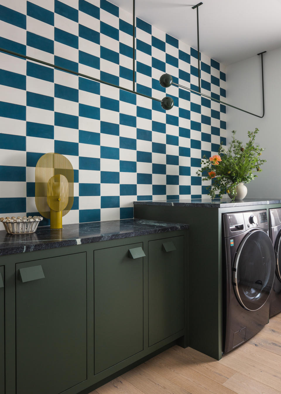 a laundry room with checkerbord wallpaper and custom hanging storage