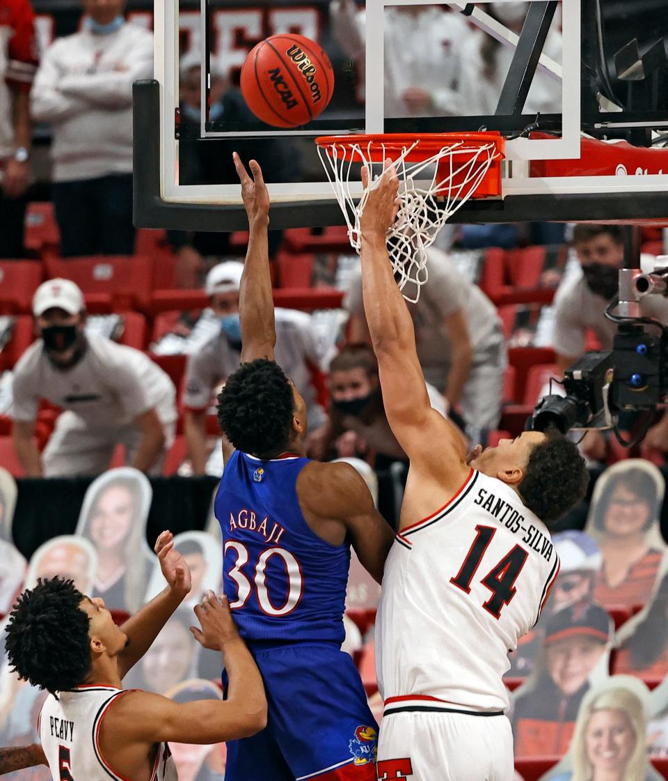 Kansas' Ochai Agbaji (30) shoots the game-winning shot around Texas Tech's Marcus Santos-Silva (14) during the second half of an NCAA college basketball game against Kansas, Thursday, Dec. 17, 2020, at United Supermarkets Arena in Lubbock, Texas.