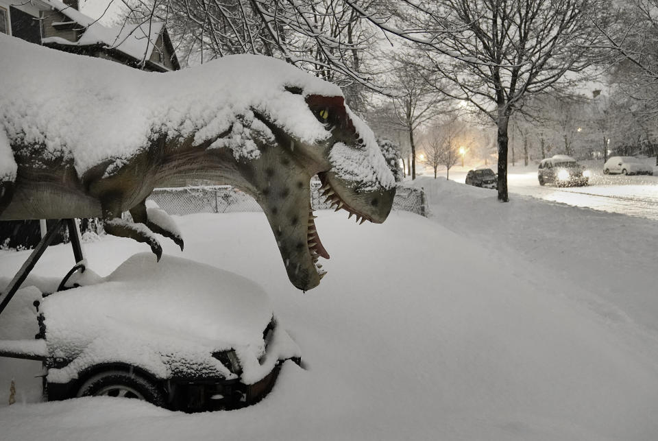 A life-size model of a T-Rex is caked in fresh snow along Portland Avenue S. Wednesday, Jan. 4, 2023 in Minneapolis, Minn. The Twin Cities has received about 10 inches of snow so far and is expecting 2 to 4 inches of new snow in the next 24 hours.(David Joles/Star Tribune via AP)