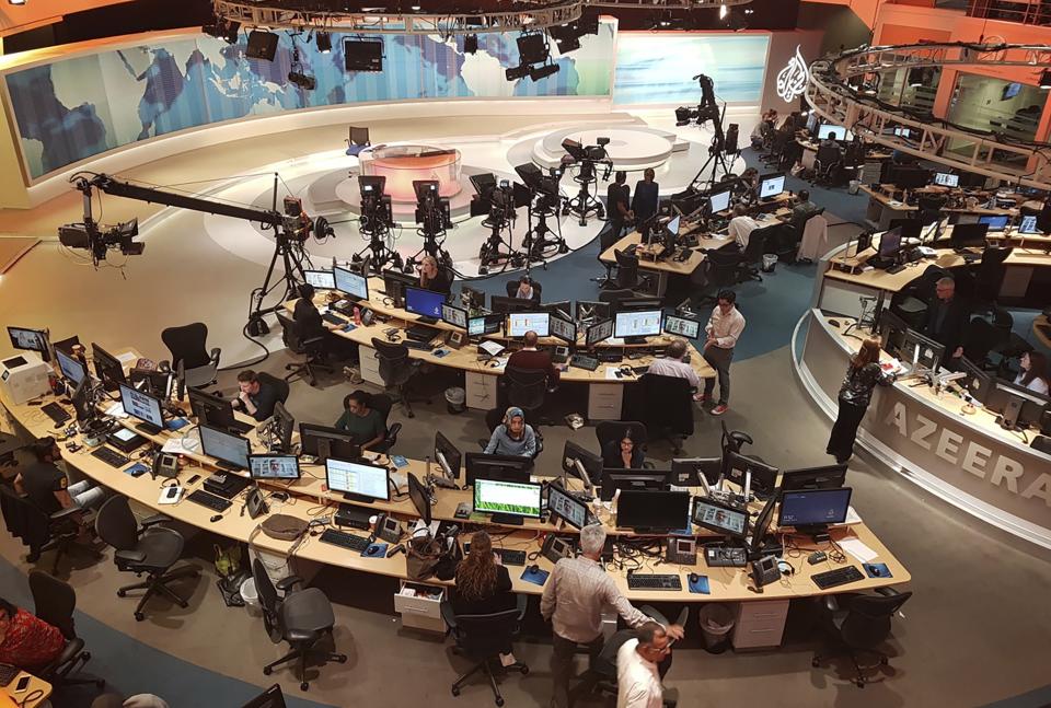 FILE - Al-Jazeera staff work at their TV station in Doha, Qatar, Thursday, June 8, 2017. World Cup fans could bring political tensions to quiet Qatar. (AP Photo/Malak Harb, File)