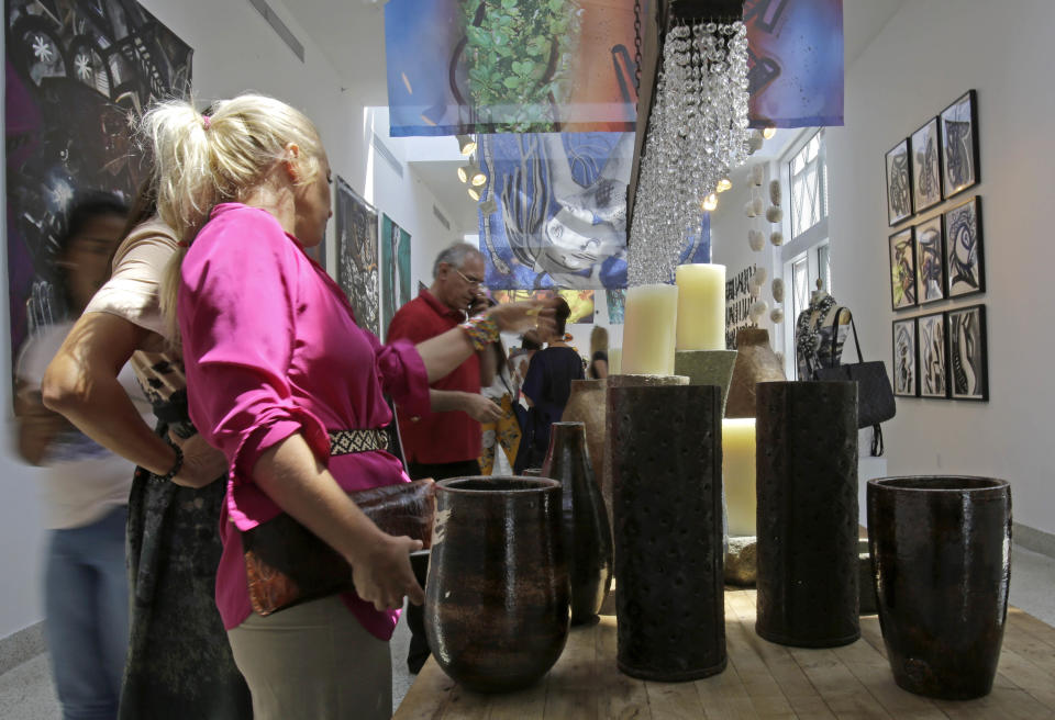 Visitors check art, furnishing and accessories at the Discover Haiti Exhibition in the Little Haiti area of Miami, Friday, May 17, 2013. (AP Photo/Alan Diaz)