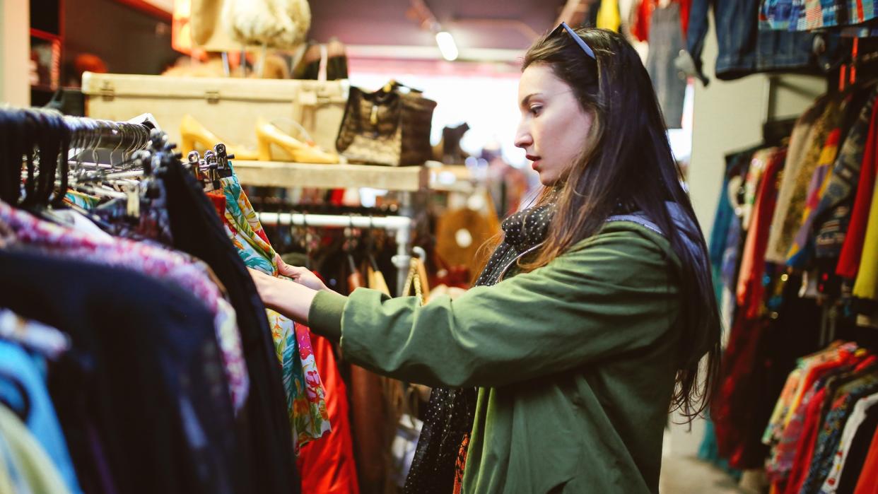 Vintage toned portrait of a young beautiful brunette woman in London second hand marketplace.