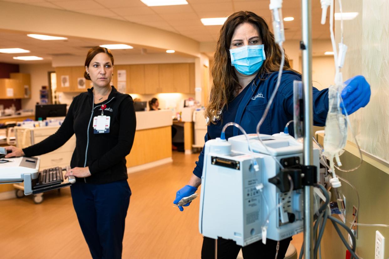 Registered nurses Krystal Schmidt, left, and Denise Silverman administer care to a cancer patient at the UCHealth Medical Center of the Rockies outpatient infusion clinic on March 15, 2023, in Loveland. UCHealth and Banner Health facilities are now implementing seasonal visitor restrictions because of an uptick in hospitalizations due to respiratory illnesses.