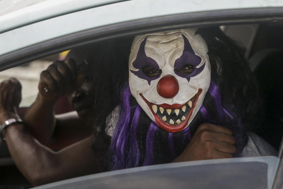 A passenger sits in a car wearing a mask, which he said was to prevent him catching the new coronavirus, in Lagos, Nigeria Friday, March 27, 2020. The new coronavirus causes mild or moderate symptoms for most people, but for some, especially older adults and people with existing health problems, it can cause more severe illness or death. (AP Photo/Sunday Alamba)