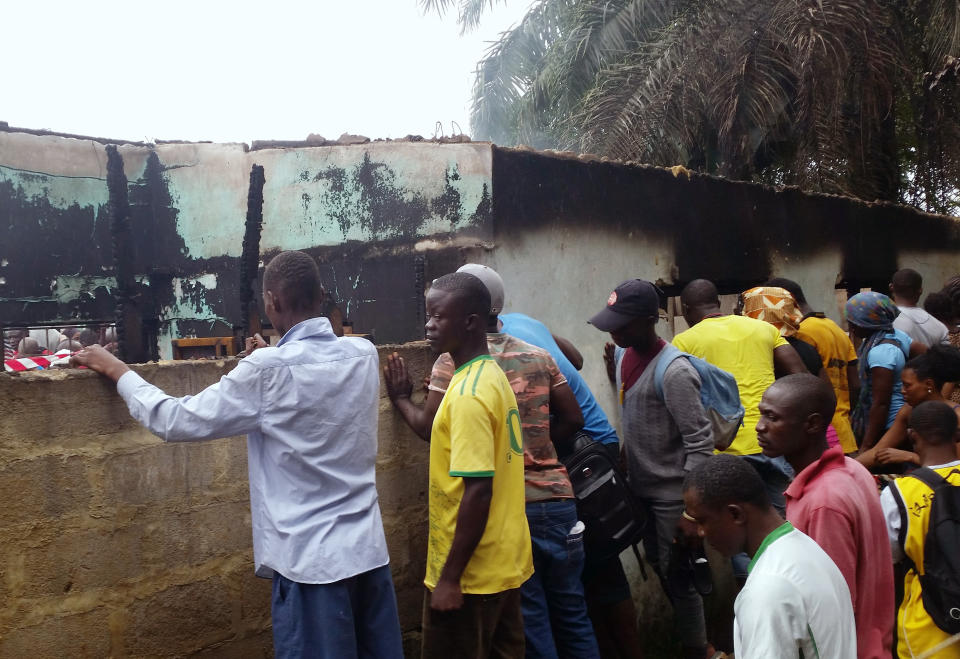 Local people turn out to view the scene of an overnight fire in Paynesville, 7 miles north east of Monrovia, Wednesday, Sept. 18, 2019. Police in Liberia say a fire at a Quranic school outside the capital, Monrovia, has killed more than 20 people and many are thought to be children. A police spokesman says the fire around midnight gutted a dormitory and school building where students slept. (AP Photo/Jonathan Paye-Layleh)