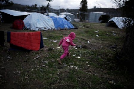 A refugee girl from Syria runs at a makeshift camp for refugees and migrants next to the Moria camp on the island of Lesbos, Greece, December 1, 2017. REUTERS/Alkis Konstantinidis