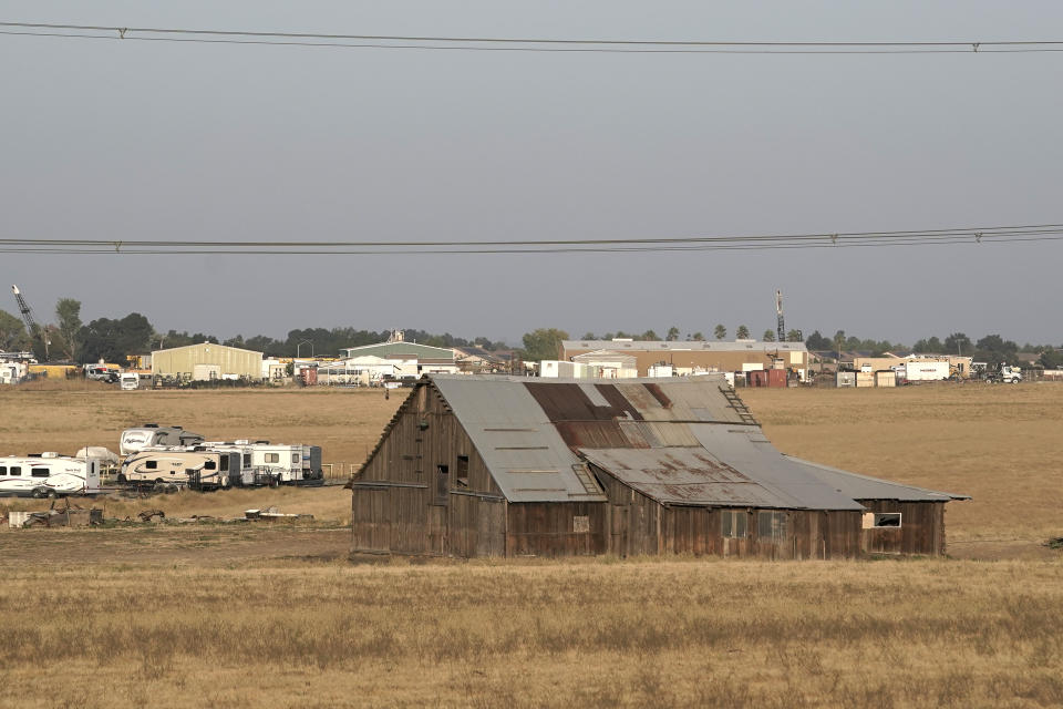 A farm building and RV's are seen near Rio Vista, Calif., Wednesday, Aug. 30, 2023. Silicon Valley billionaires and investors are behind a years-long, secretive land buying spree of more than 78 square miles (202 square kilometers) of farmland in Solano County with the goal of creating a new city. (AP Photo/Godofredo A. Vásquez)