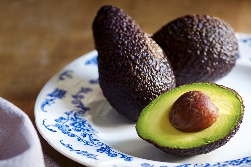 Whole and halved avocados