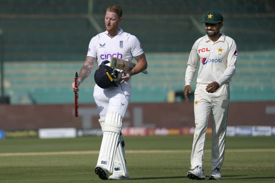 England's skipper Ben Stokes, left, holds wicket as he walks with his Pakistani counterpart Babar Azam after winning the third test cricket match against Pakistan, in Karachi, Pakistan, Tuesday, Dec. 20, 2022. (AP Photo/Fareed Khan)