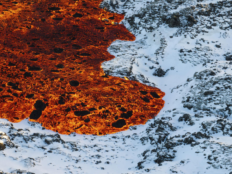 Lava crosses the main road to Grindavík and flows on the road leading to the Blue Lagoon, in Grindavík, Iceland, Thursday, Feb. 8, 2024. A volcano in southwestern Iceland has erupted for the third time since December and sent jets of lava into the sky. The eruption on Thursday morning triggered the evacuation the Blue Lagoon spa which is one of the island nation’s biggest tourist attractions. (AP Photo /Marco Di Marco)