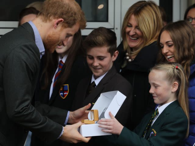 Prince Harry is presented with a Passchendaele 100 Poppy Pin by 11-year-old Phoebe Taylor