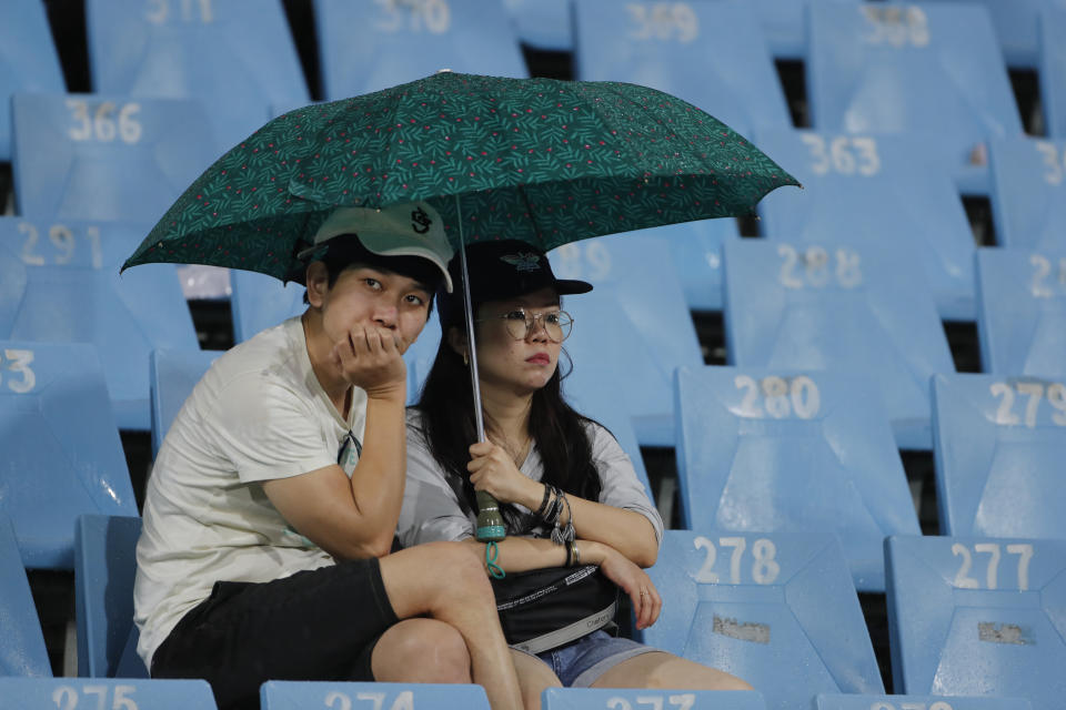 A couple sits under an umbrella and wait for the play to resume after rains stopped it during the Indian Premier League cricket match between Lucknow Super Giants and Chennai Super Kings was abandoned in Lucknow, India, Wednesday, May 3, 2023. (AP Photo/Surjeet Yadav)