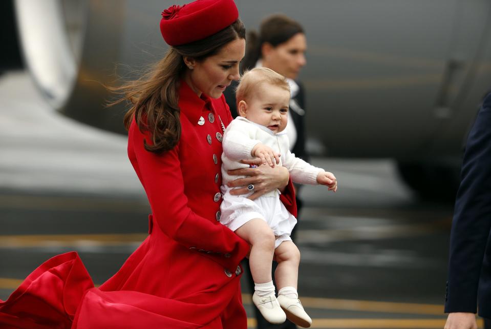 Catherine holds her son Prince George after disembarking from plane in Wellington