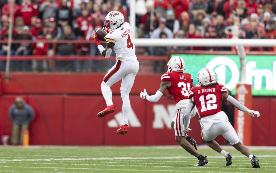 Maryland's Shaleak Knotts (4) catches a pass against Nebraska's Tommi Hill (31) and Omar Brown (12) during the first half of an NCAA college football game Saturday, Nov. 11, 2023, in Lincoln, Neb. (AP Photo/Rebecca S. Gratz)