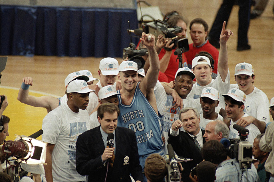 FILE - In this April 5, 1993, file photo, North Carolina coach Dean Smith at front center right, points as he celebrates a 77-71 win against Michigan in the NCAA Final Four championship basketball game in New Orleans. At center is Eric Montross (00). The game wasn’t settled until Michigan’s Chris Webber called a timeout the Wolverines didn’t have with 11 seconds to go. ″You can call it lucky, you can call it fortunate, but it still says NCAA championship,″ Smith said. (AP Photo/Bob Jordan, File)