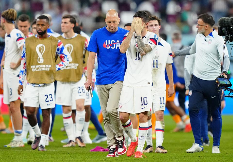 United States of America manager Gregg Berhalter consoles forward Christian Pulisic (10) after losing a round of sixteen match against the Netherlands in the 2022 FIFA World Cup.