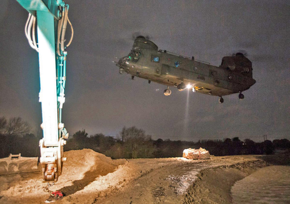 An RAF Chinook in Doncaster moving tonnes of aggregate to a cut off a spit of land to shore up flood defences (Picture: PA)