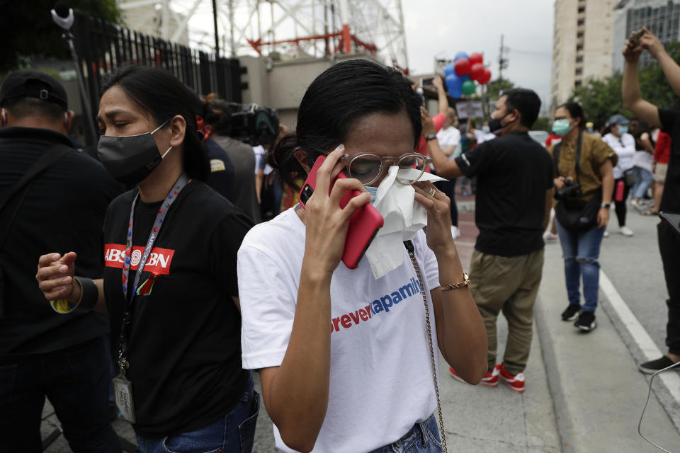 A supporter wipes her tears after hearing the results of the voting at the House of Representative for the franchise renewal of ABS-CBN at the company headquarters of ABS-CBN in Quezon City, Philippines, Friday, July 10, 2020. Philippine lawmakers voted Friday to reject the license renewal of the country's largest TV network, shutting down a major news provider that had been repeatedly threatened by the president over its critical coverage. (AP Photo/Aaron Favila)