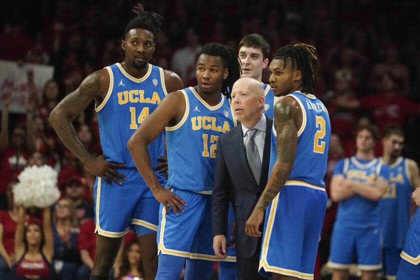 UCLA coach Mick Cronin and players await a call against Arizona on Jan. 20, 2024.