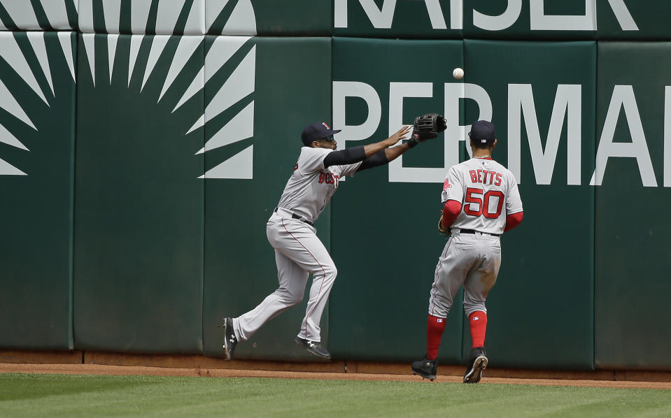 Boston Red Sox center fielder Jackie Bradley Jr., left, and right fielder Mookie Betts chase after a ball hit by the Oakland Athletics' Stephen Piscotty in the fourth inning of a baseball game Thursday, April 4, 2019, in Oakland, Calif. Piscotty hit a ground rule double and two runs scored on the play. (AP Photo/Eric Risberg)