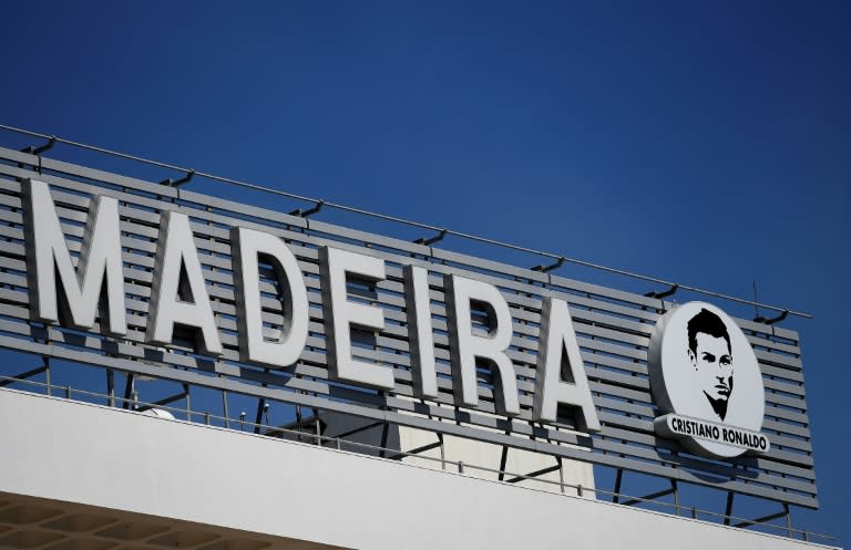 The Madeira airport sign in Funchal flanked by a portrait of Portuguese footballer Cristiano Ronaldo during a ceremony renaming the airport after the footballer on March 29, 2017