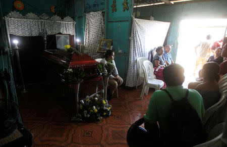 Relatives and friends sit next to the coffin of Darwin Manuel Urbina, 29, who according to nation's Red Cross was shot dead during a protest over a controversial reform to the pension plans of the Nicaraguan Social Security Institute (INSS) in Managua, Nicaragua April 21, 2018. REUTERS/Jorge Cabrera