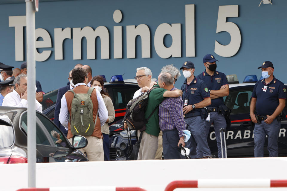 A group including Italian diplomats, civilians and Afghan collaborators leave Rome's Fiumicino international airport, after disembarking from an Italian Air force plane that evacuated them from Kabul, Afghanistan, Monday, Aug. 16, 2021. (AP Photo/Riccardo De Luca)