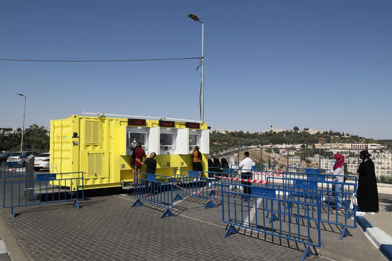 People stand in a queue as they wait to get tested for the coronavirus disease (COVID-19) in East Jerusalem