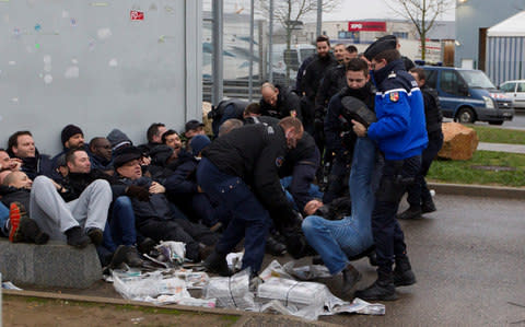 Prison wardens are gathered by French gendarmes as they block the Lyon-Corbas jail near Lyon - Credit: REUTERS/Emmanuel Foudrot