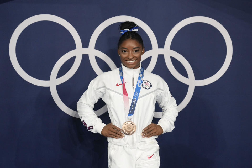 FILE - Simone Biles, of the United States, poses wearing her bronze medal from balance beam competition during artistic gymnastics at the 2020 Summer Olympics, Aug. 3, 2021, in Tokyo, Japan. President Joe Biden will present the nation's highest civilian honor, the Presidential Medal of Freedom, to 17 people, at the White House next week. (AP Photo/Natacha Pisarenko, File)