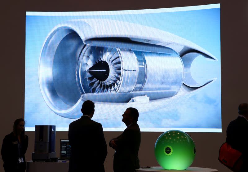 FILE PHOTO: Visitors talk on the Rolls Royce stand during the EBACE at Cointrin Airport in Geneva