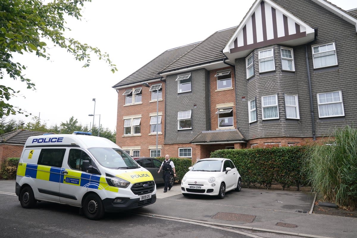 A police officer leaves the scene at Clariat Court in Boddington Gardens where Aziza Bennis was found fatally stabbed (PA)