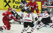 Yevgeni Timkin of Russia, left, scoring against Darcy Kuemper of Canada during the Ice Hockey World Championship quarterfinal match between Russia and Canada at the Olympic Sports Center in Riga, Latvia, Thursday, June 3, 2021. (AP Photo/Roman Koksarov)