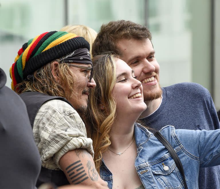 Depp firma autógrafos y posa con fans cuando sale de su hotel en Manchester