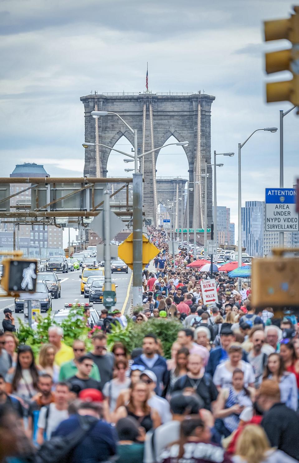 A large group of visitors on the Brooklyn Bridge.