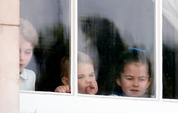 LONDON, UNITED KINGDOM - JUNE 08: (EMBARGOED FOR PUBLICATION IN UK NEWSPAPERS UNTIL 24 HOURS AFTER CREATE DATE AND TIME) Prince George of Cambridge, Prince Louis of Cambridge (sucking his thumb) and Princess Charlotte of Cambridge look out of a window of Buckingham Palace as they attend Trooping The Colour, the Queen's annual birthday parade, on June 8, 2019 in London, England. The annual ceremony involving over 1400 guardsmen and cavalry, is believed to have first been performed during the reign of King Charles II. The parade marks the official birthday of the Sovereign, although the Queen's actual birthday is on April 21st. (Photo by Max Mumby/Indigo/Getty Images)