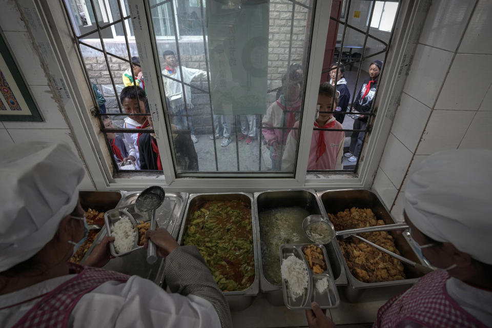 Tibetan students collect their meals at a canteen in the Shangri-La Key Boarding School during a media-organized tour in Dabpa county, Kardze Prefecture, Sichuan province, China on Sept. 5, 2023. (AP Photo/Andy Wong)