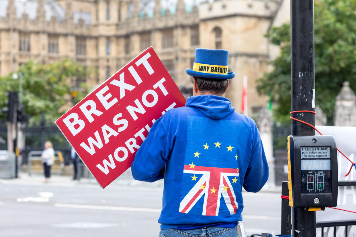 A man wearing a hoodie printed with the EU and UK flags and holding a placard that says 'Brexit was not worth it' during a demonstration in London. (SOPA Images/Sipa USA)