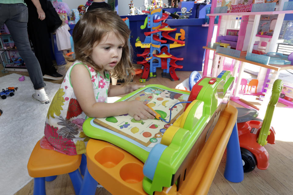 In this Aug. 30, 2018, photo Seraphina, 3, plays with a V-Tech Explore and Write Activity Set at the Walmart Toy Shop event in New York. Walmart says 30 percent of its holiday toy assortment will be new. It will also offer 40 percent more toys on Walmart.com from a year ago. In November and December, the company’s toy area will be rebranded as “America’s Best Toy Shop.” (AP Photo/Richard Drew)
