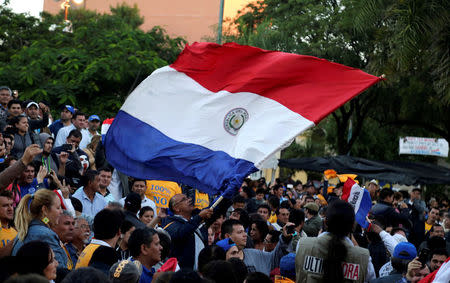 People wave a Paraguayan flag to celebrate the rejection of a proposed amendment to allow presidential second terms, in front of the Paraguayan Congress, in Asuncion, Paraguay April 26, 2017. REUTERS/Jorge Adorno