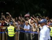 <p>People wave as the convoy of President Trump will meet with North Korean leader Kim Jong-un on June 12 in Singapore. (Photo: VCG/VCG via Getty Images) </p>