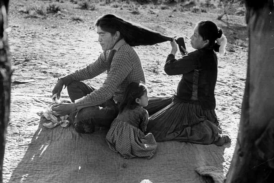 <b>Caption from LIFE.</b> Yellowsalt's son has his hair brushed by wife. Nowadays many young Navajos wear their hair short.