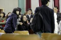 Students watch the news screen which shows the sinking vessel at auditorium at Danwon High School in Ansan, South Korea, Thursday, April 17, 2014. Strong currents, rain and bad visibility hampered an increasingly anxious search Thursday for 287 passengers, including many students from the high school for a four-day trip, still missing a day after their ferry flipped onto its side and sank in cold waters off the southern coast of South Korea. (AP Photo/Woohae Cho)