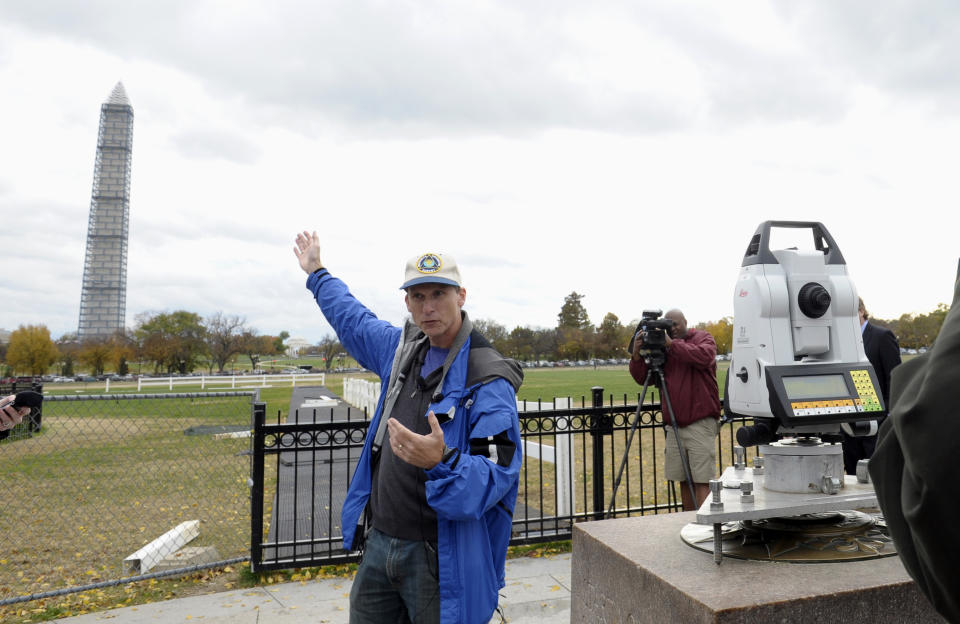 Dru Smith, Chief Geodesist of the National Geodetic Survey stands near a measurement device used to survey the height of the Washington Monument, Thursday, Nov. 7, 2013, in Washington. Surveyors are checking to make sure that the Washington Monument is still 555 feet, 5 1/8 inches tall. The survey is being conducted by the National Geodetic Survey and is the first of its kind since 1999. Surveyors can only access the peak of the monument to check the height when it's covered in scaffolding. The monument is undergoing repairs after it was damaged during a 5.8-magnitude earthquake in August 2011. (AP Photo/Susan Walsh)