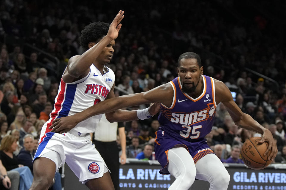 Phoenix Suns forward Kevin Durant (35) shields the ball from Detroit Pistons forward Ausar Thompson during the second half of an NBA basketball game, Wednesday, Feb. 14, 2024, in Phoenix. (AP Photo/Rick Scuteri)