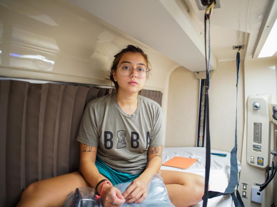 The author sits on the bed in the roomette