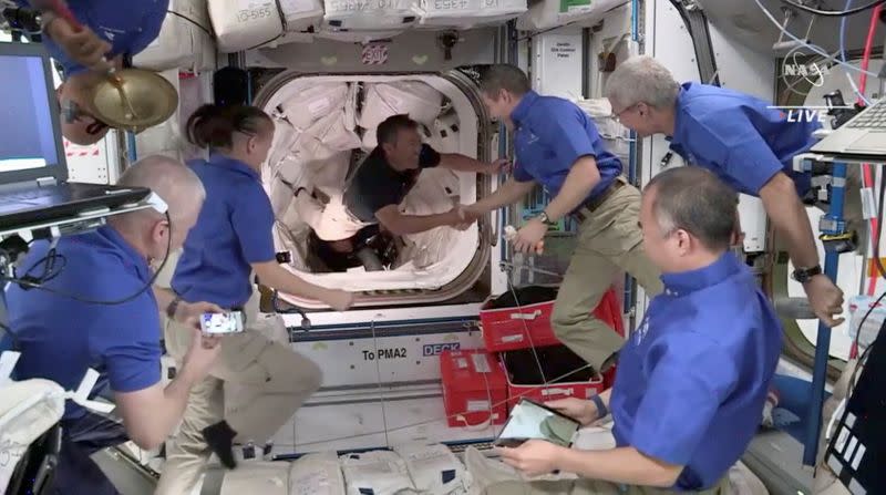 El astronauta de JAXA Akihiko Hoshide (japón) es bienvenido por la tripulación 1 a bordo de la Estación Espacial Internacional